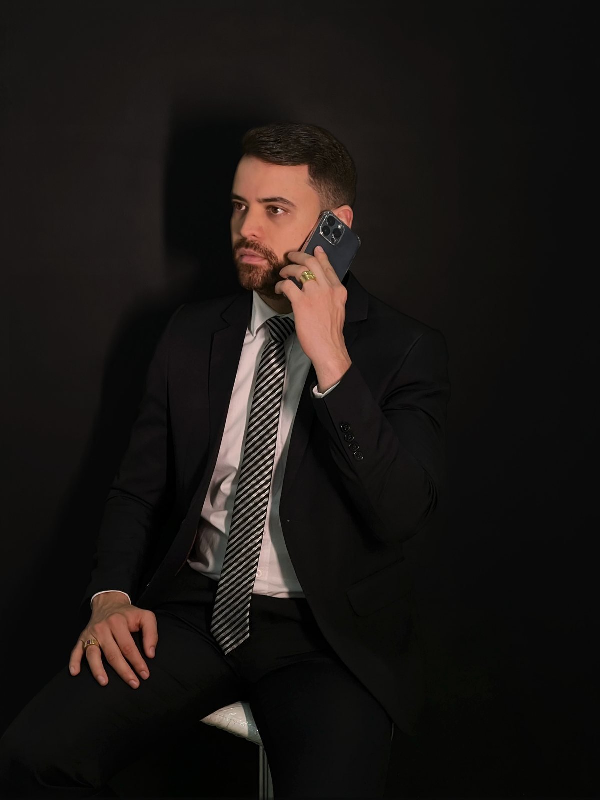 Dr. João Bruno Nascimento Borges atendendo ao telefone, de terno