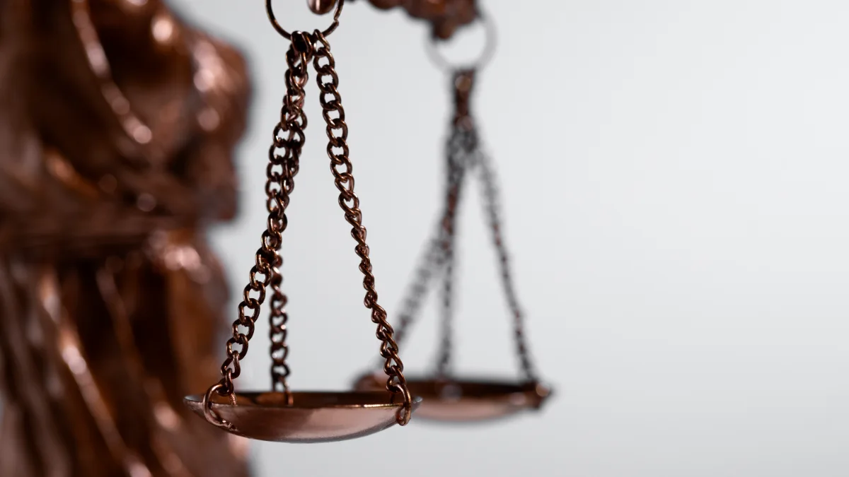 Balança da Justiça em close, com fundo claro