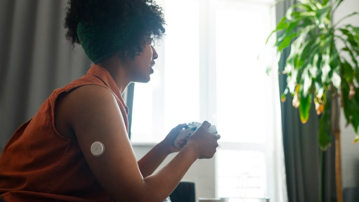 Mulher com sensor de glicose no braço em casa